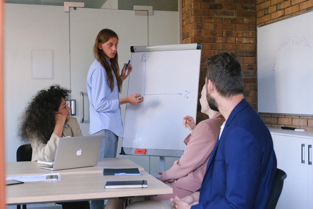 Colleagues discussing a business strategy during a meeting with a flip chart presentation.